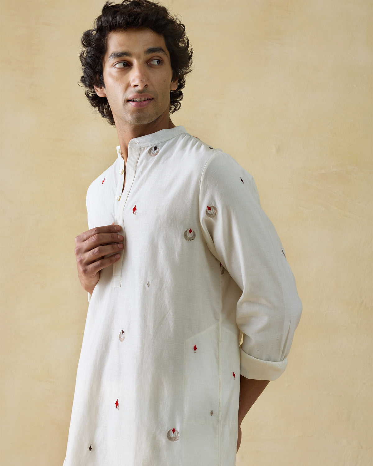 Person wearing an ivory Neckband Kurta with a band collar and scattered embroidery.