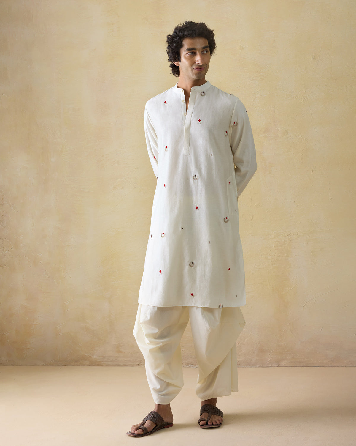 Person wearing a full-length ivory Neckband Kurta with scattered embroidery.
