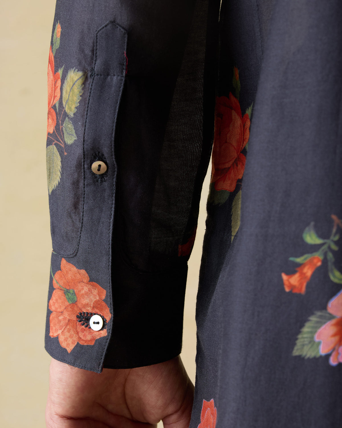 Close-up of the sleeve cuff and floral print on a charcoal Ibn kurta.