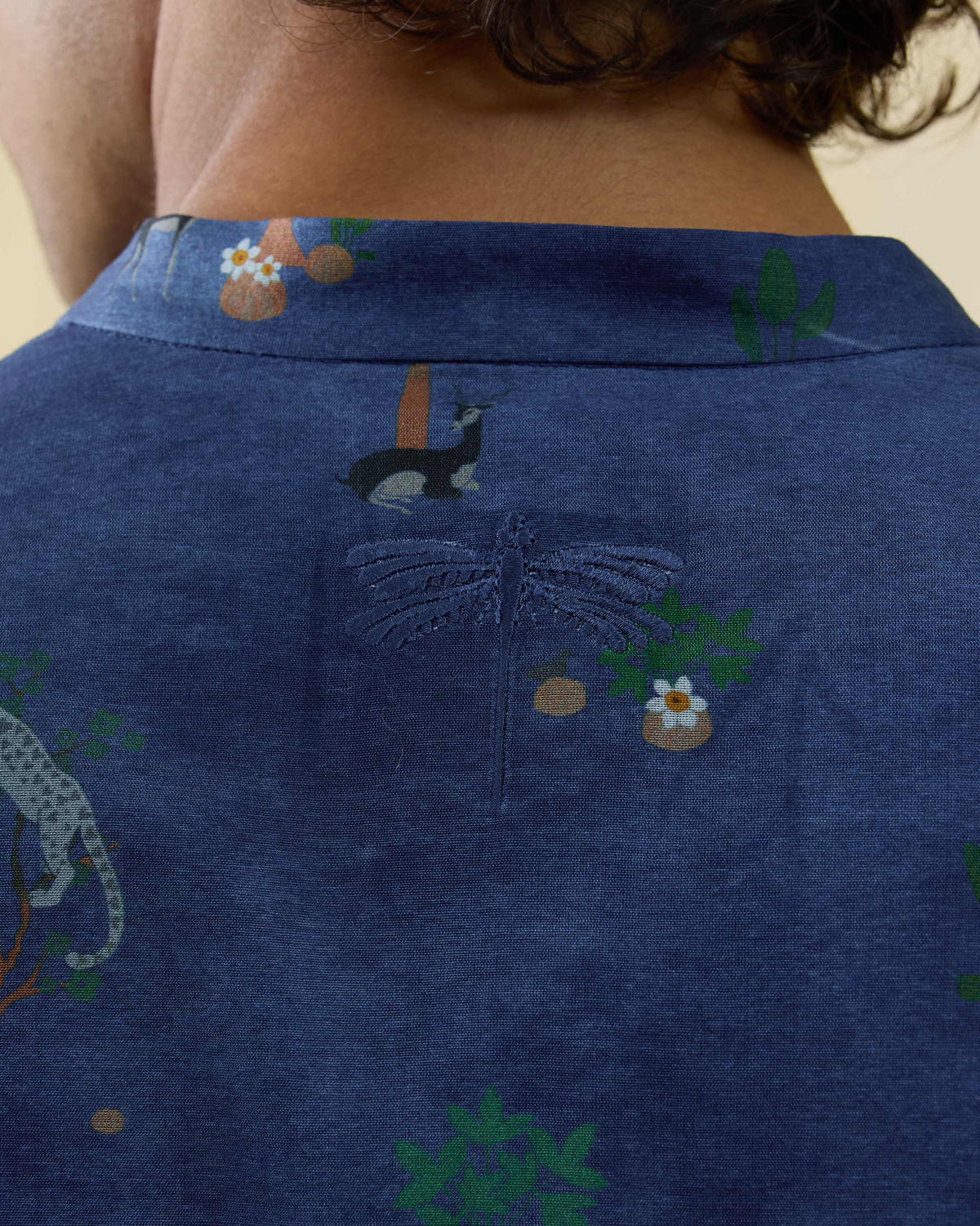 Close-up of a dragonfly on the back of a teal blue Astral kurta.