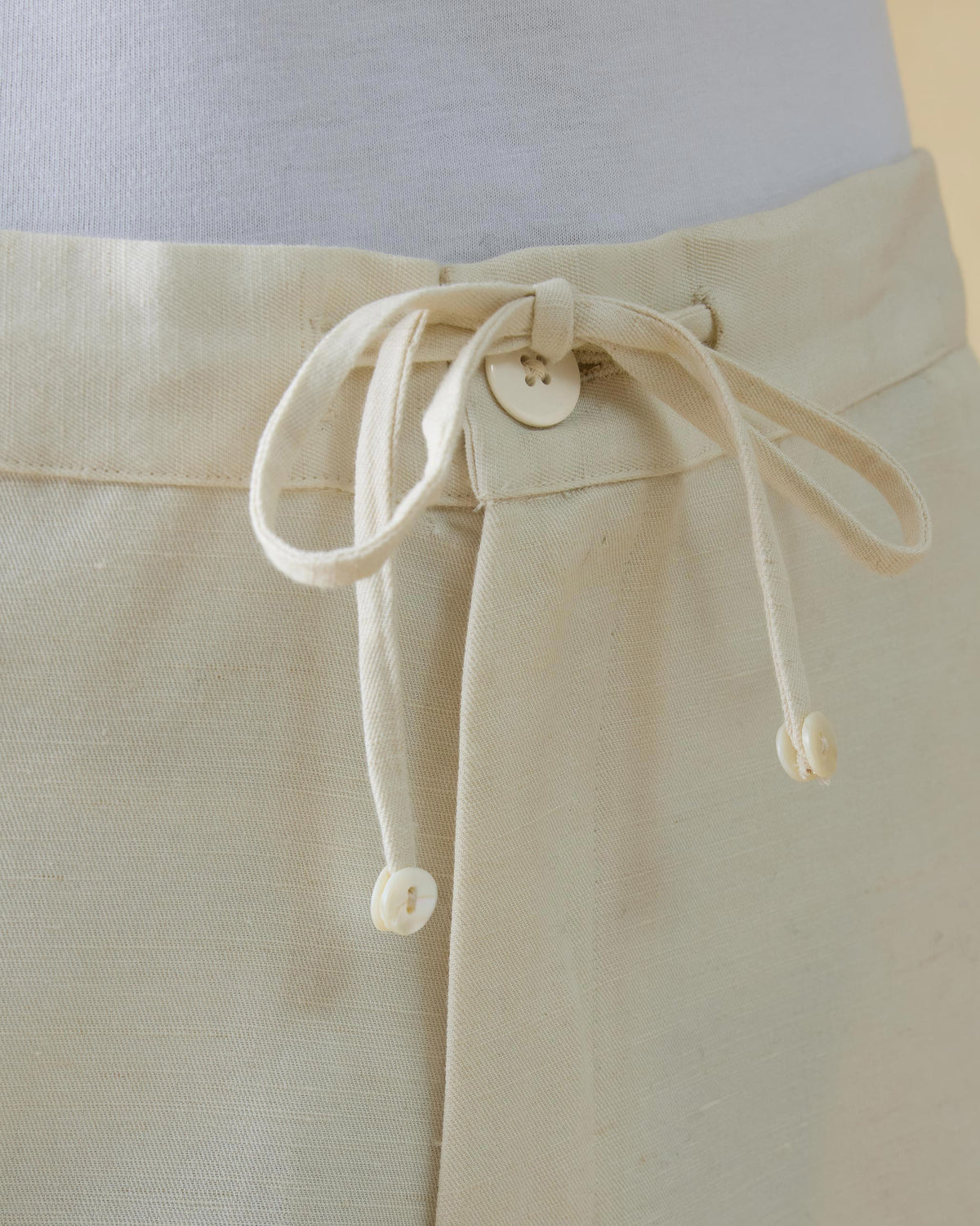 Close-up of the ivory Aaram pants drawstring waistband.