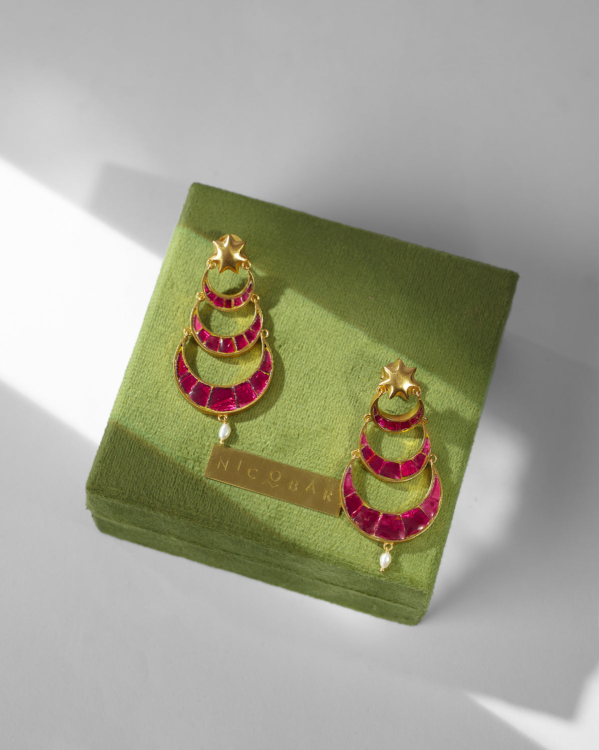 Pair of Gul-Chand Earrings resting on a green velvet box.