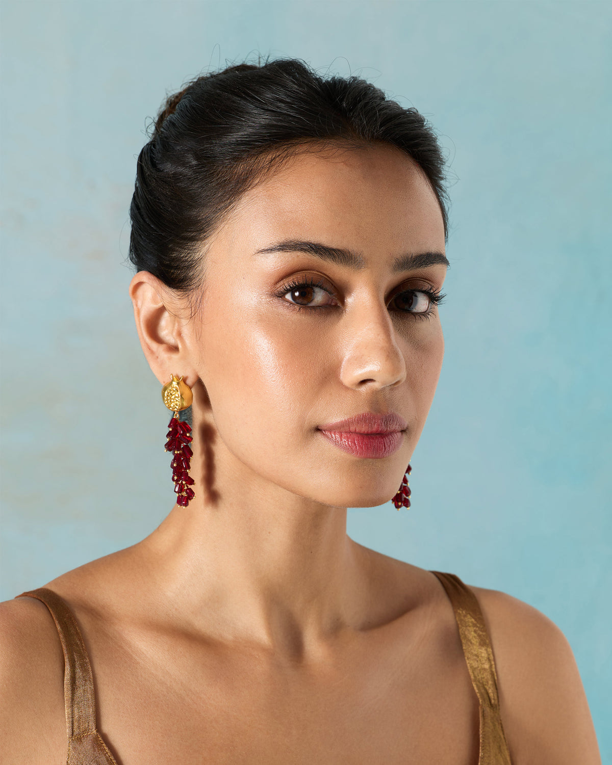 Person wearing Anaar Bagicha Earring, with a gold pomegranate top and red drops.