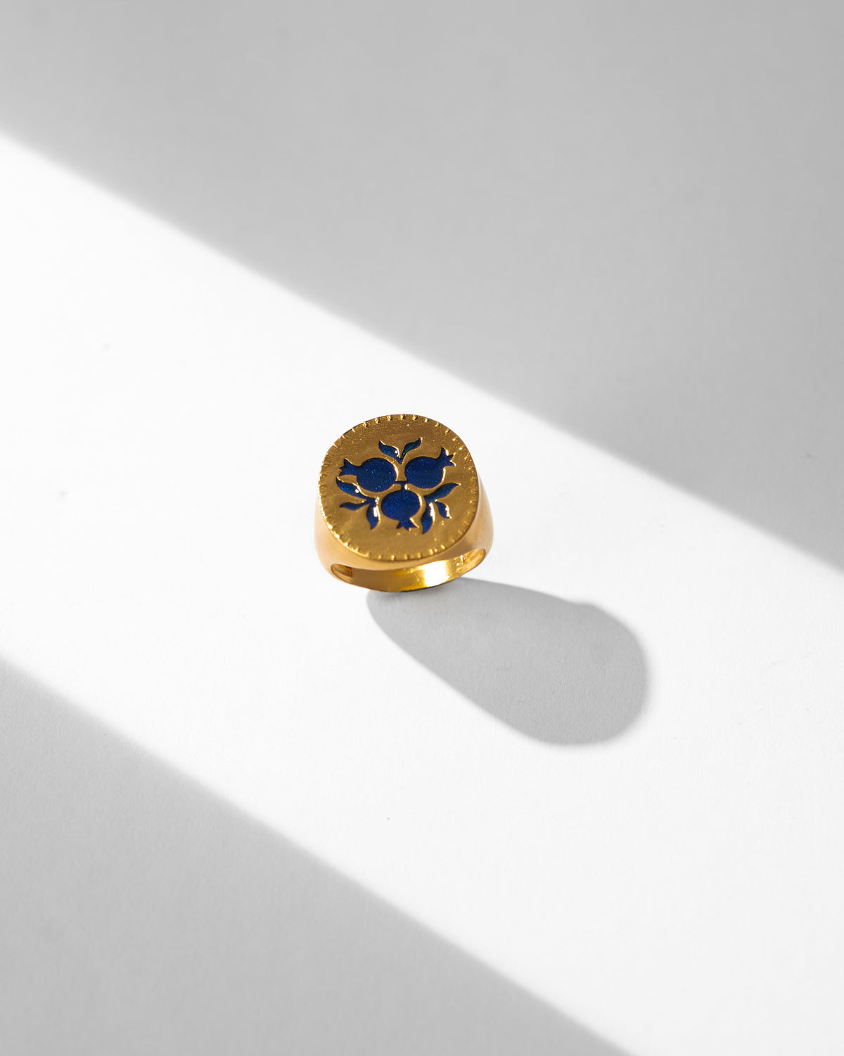 Gold Anar signet ring with three blue enamel pomegranates on the face.