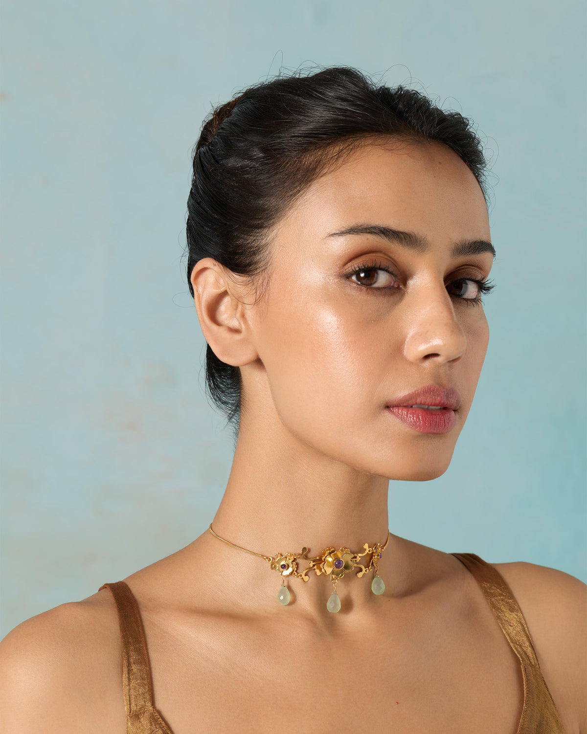 Front view of a Kesar choker with pale green drops worn by a person.