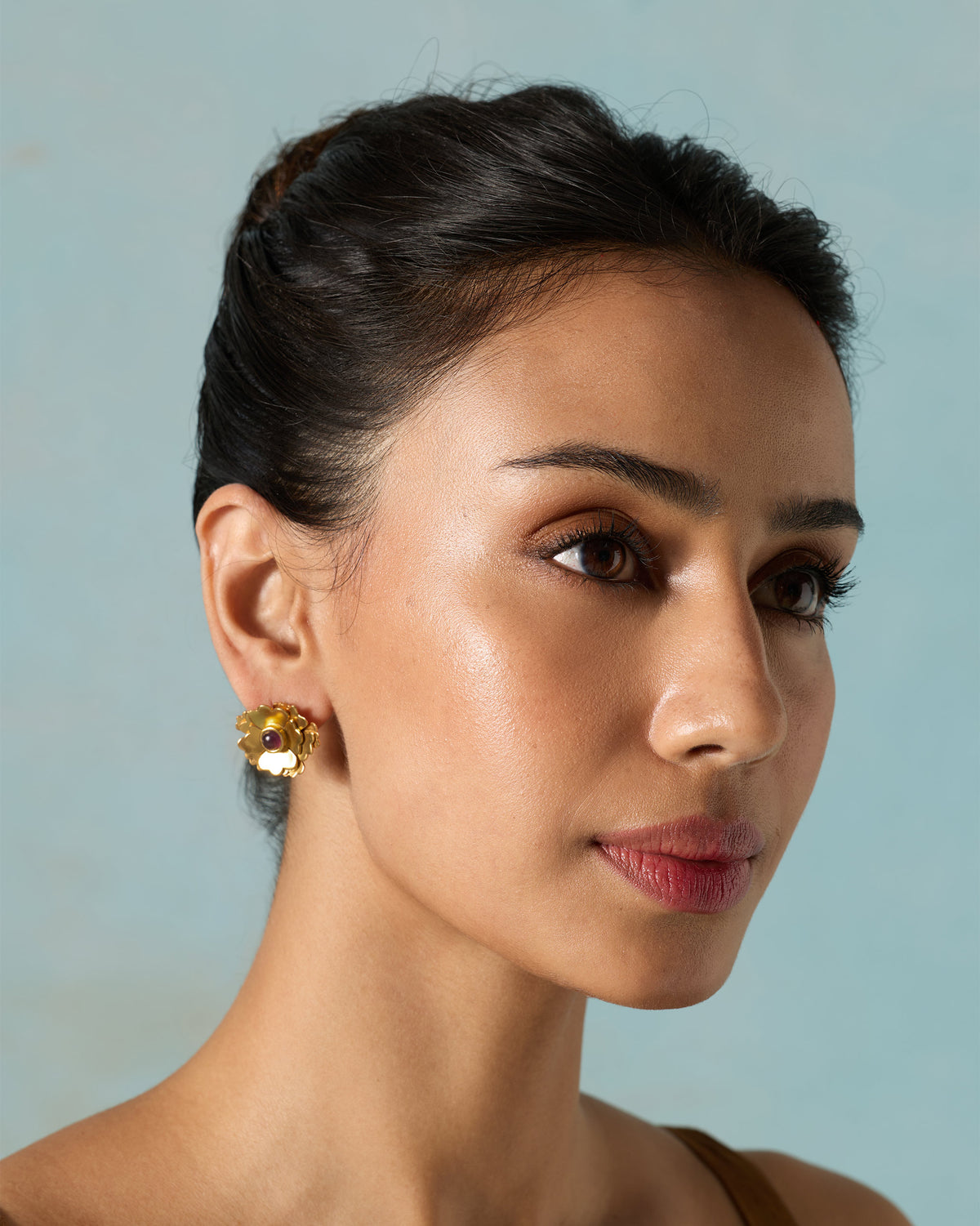 Side view of a person wearing a Kesar Phool Stud on one ear.