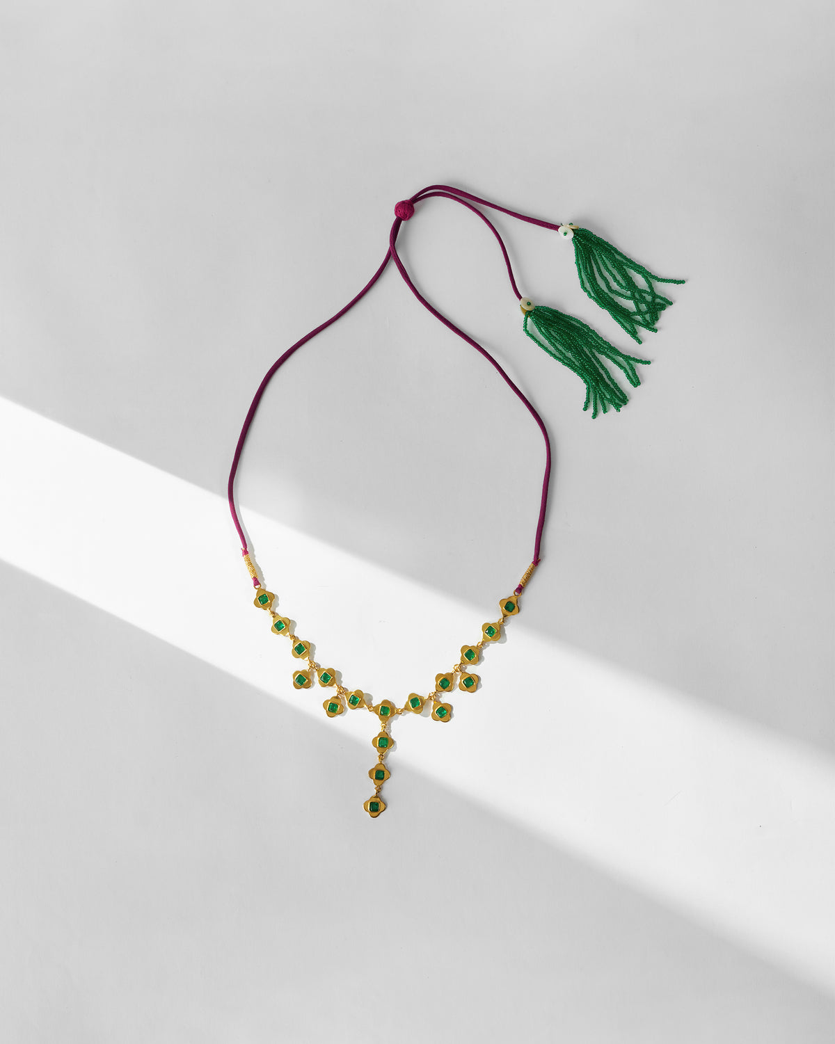 Gold Clover necklace with green glass links and green beaded tassels.