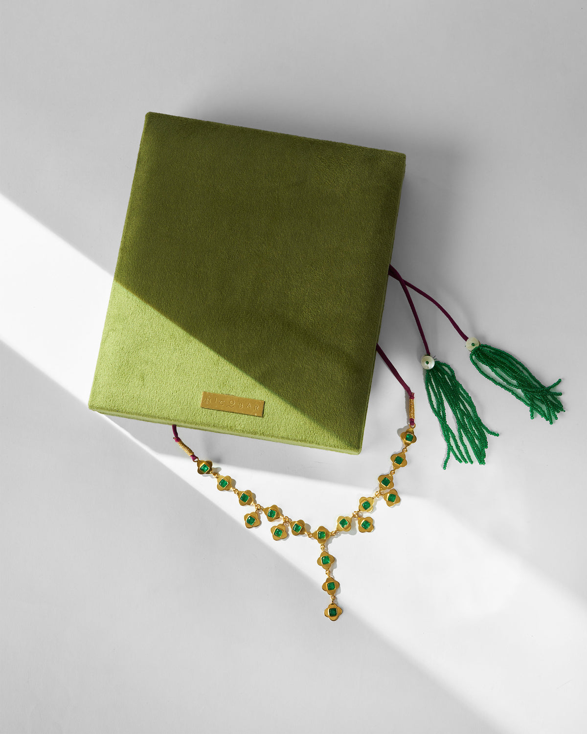 Gold Clover necklace with an olive Nicobar velvet gift box.