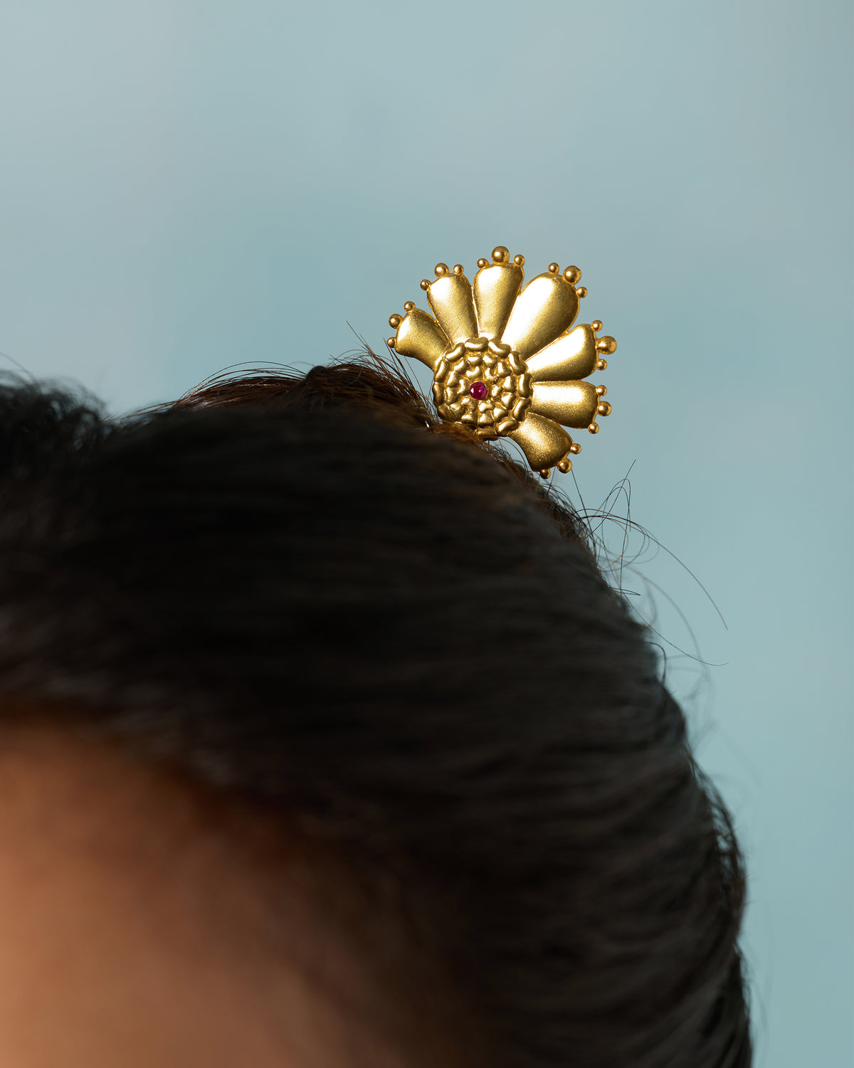 Gold Mari-Palm hairpin with a petal fan in a bun.