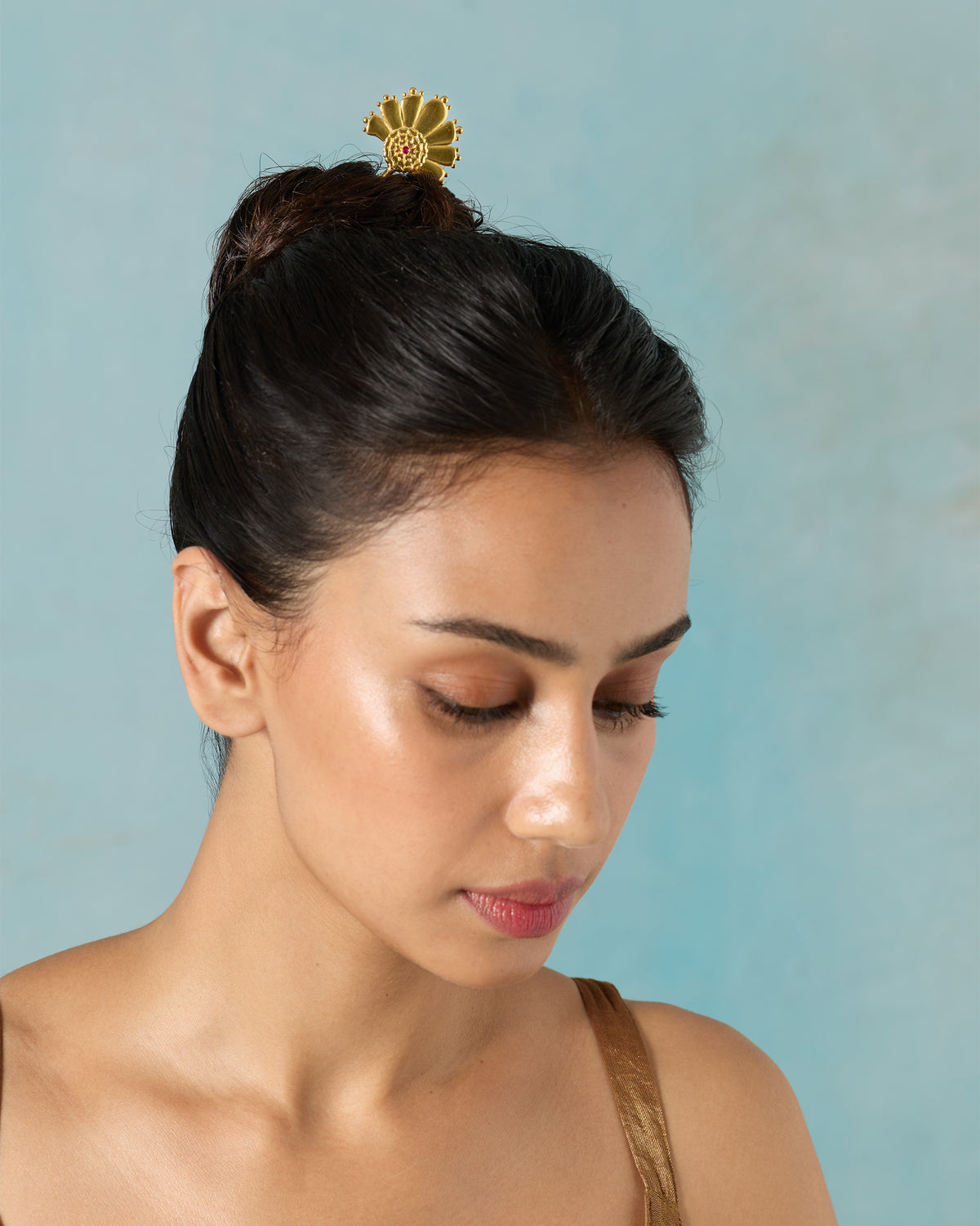 Person wearing a gold Mari-Palm hairpin in a bun.