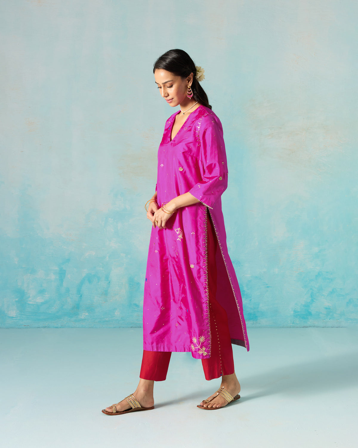 Person turned sideways in a magenta Milni kurta with a long side slit.