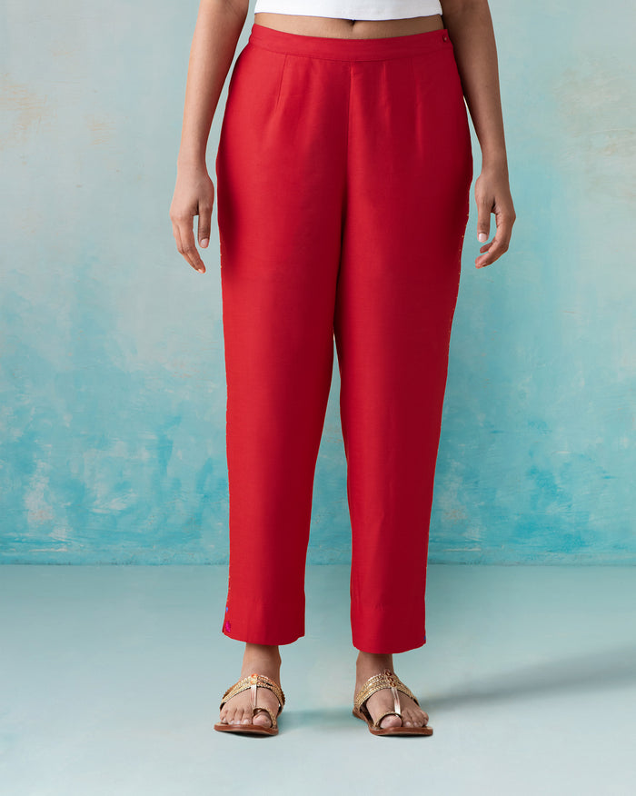 Person wearing bright red Novel pants with a narrow straight fit.