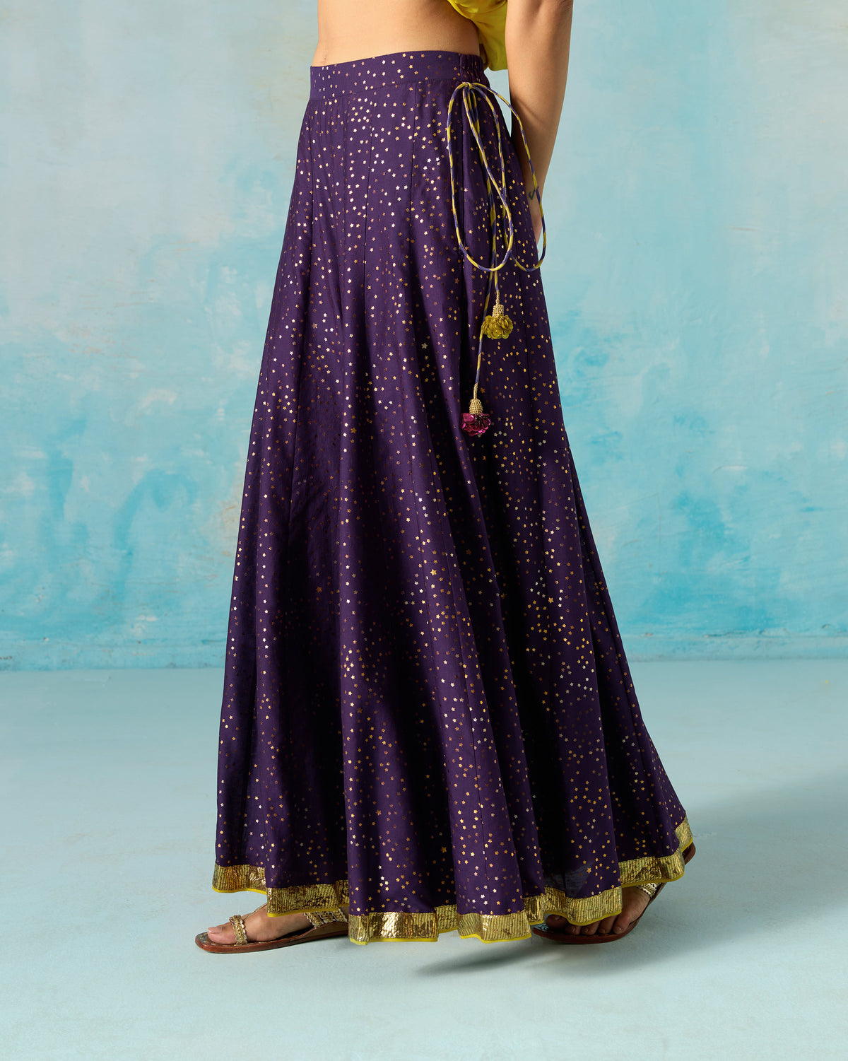 Side view of a purple Sagan sharara with gold foil dots and colourful waist tassels.