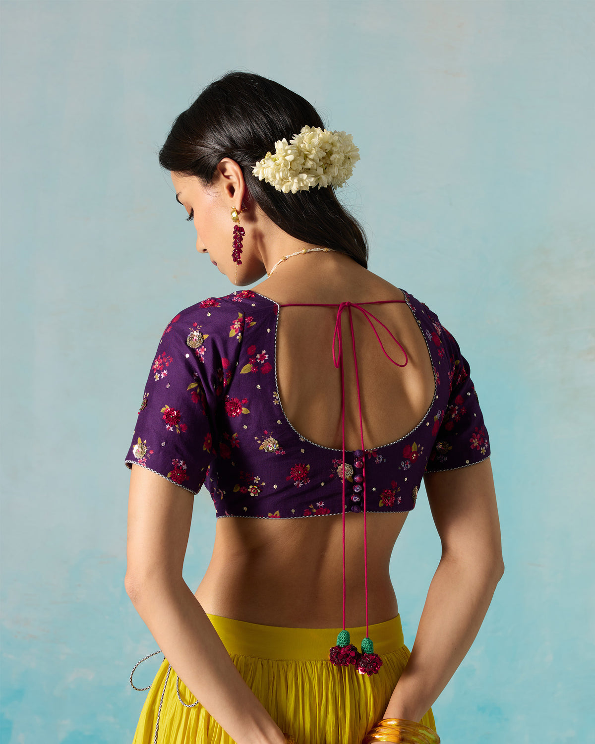Close-up of the Dori blouse sleeve with floral print and sequin embroidery.