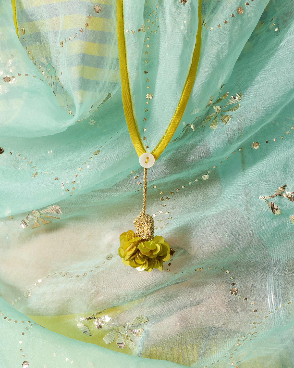 Close-up of silver mukaish embroidery and a sequin tassel on a sea foam Adaa Dupatta.