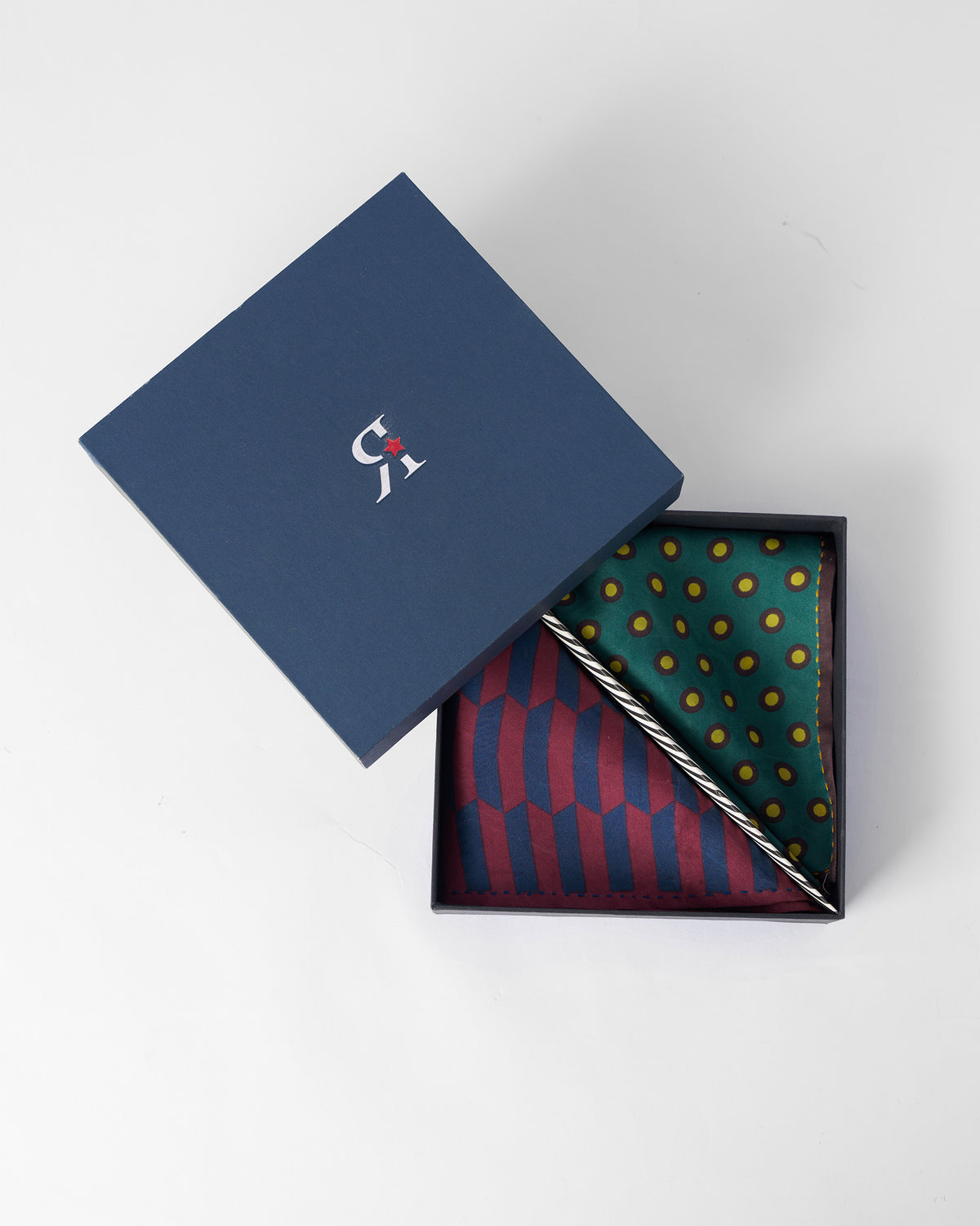 Drongo silk pocket squares presented in an open navy gift box.