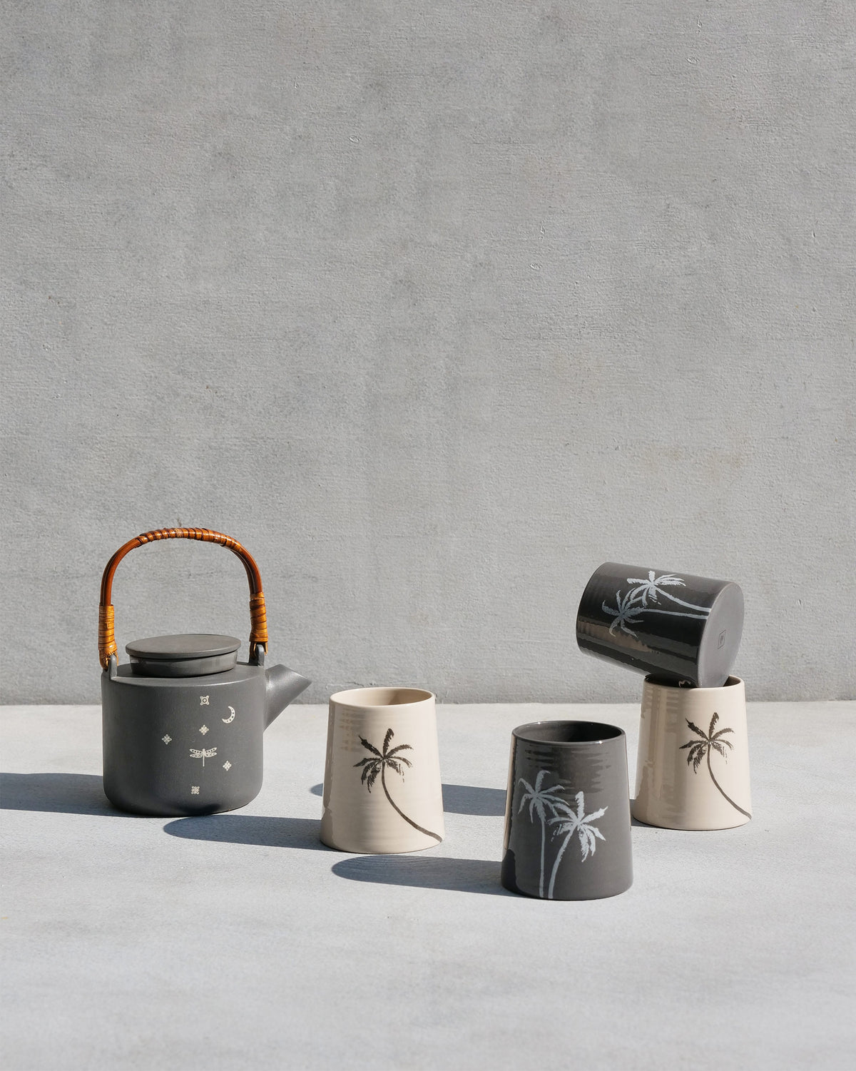 Taramandal tea set with a charcoal teapot and cream and charcoal palm kulhars.