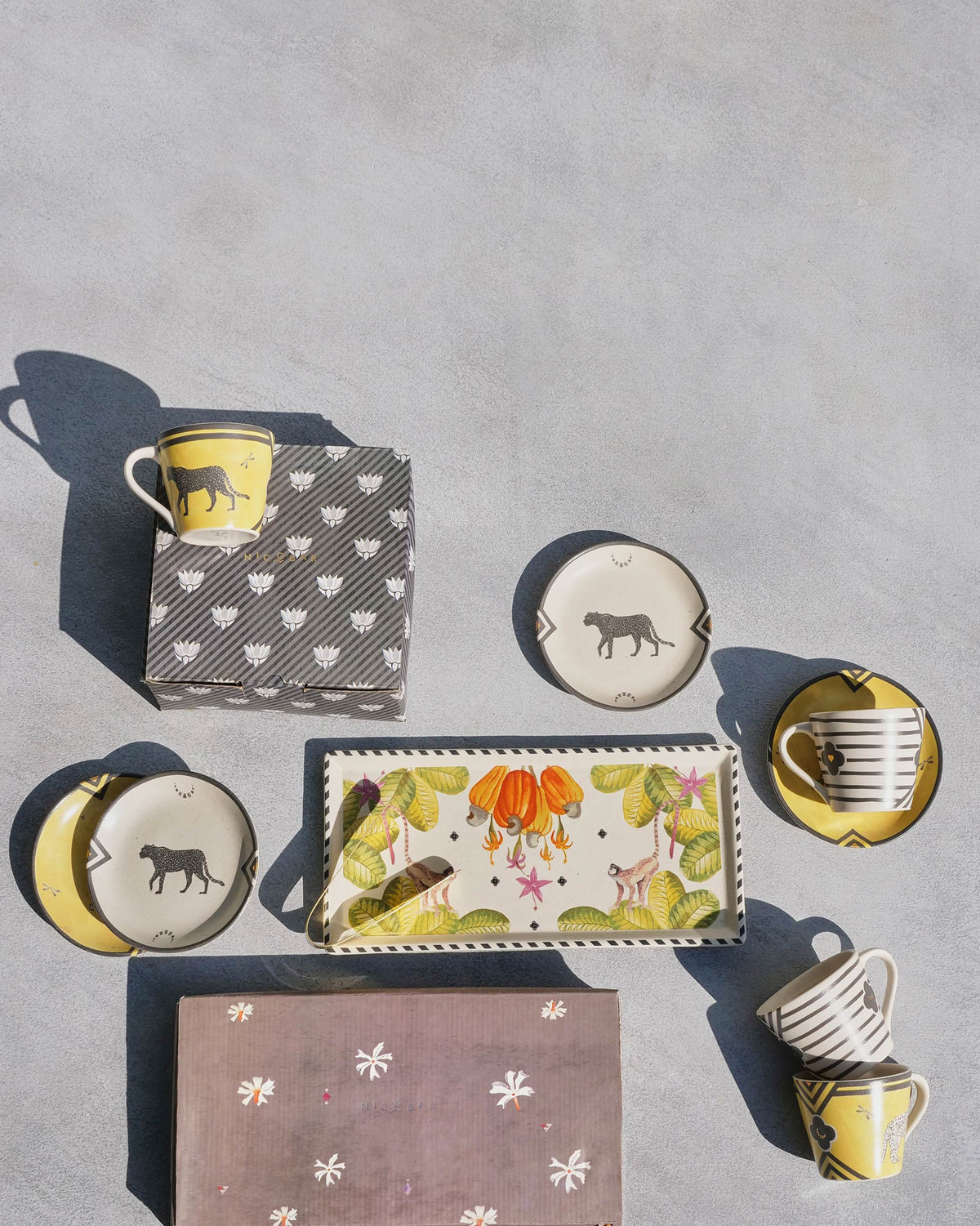 Overhead Chand Coffee Set with mugs, cheetah plates, tray, and gift boxes.