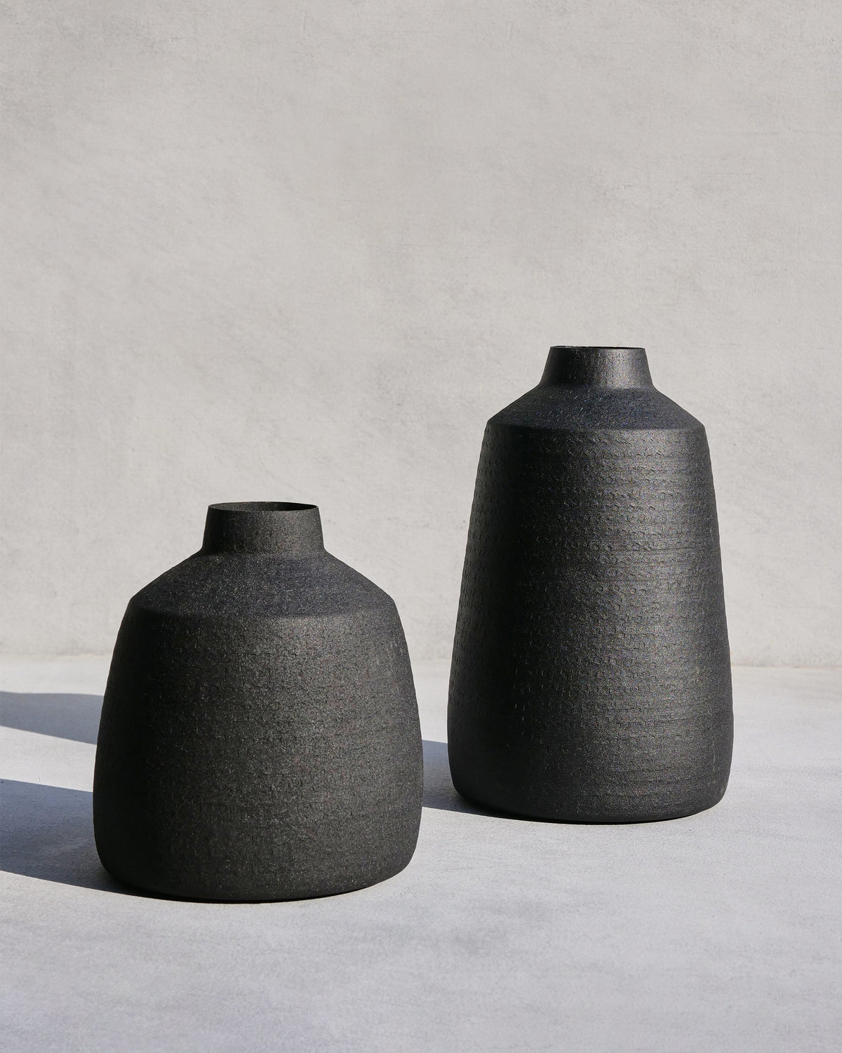 Midnight vase set with two matte black textured iron vases.
