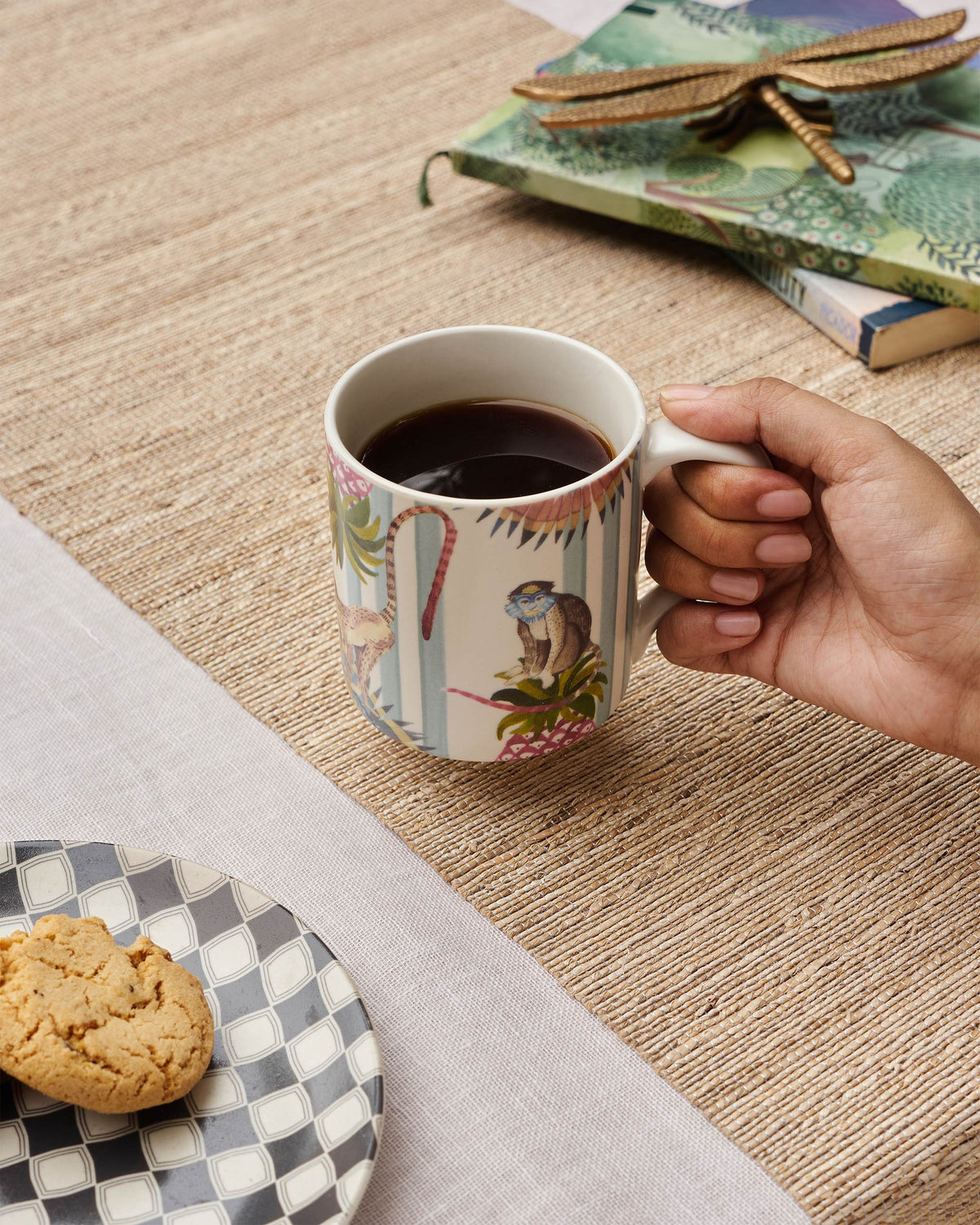 Person holding an ivory Mahi Mug by its handle.