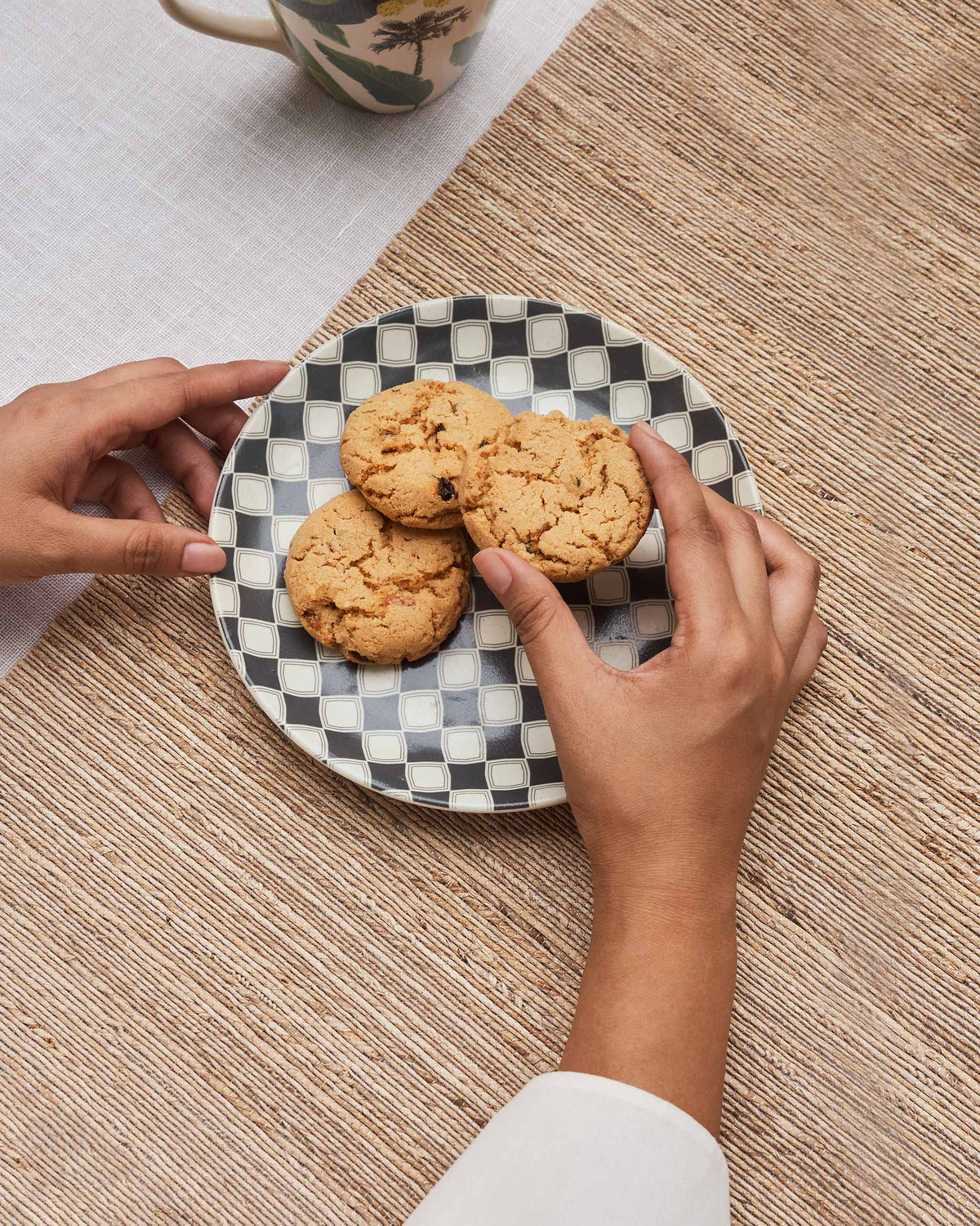 Fez quarter plate with charcoal checker pattern holding cookies on a woven mat.