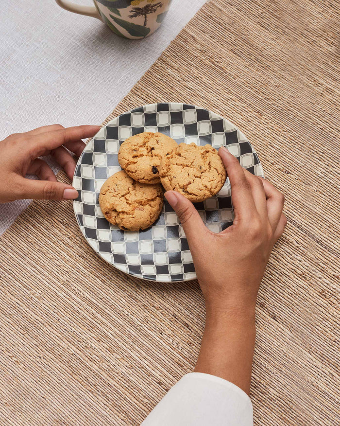 Fez quarter plate with charcoal checker pattern holding cookies on a woven mat.