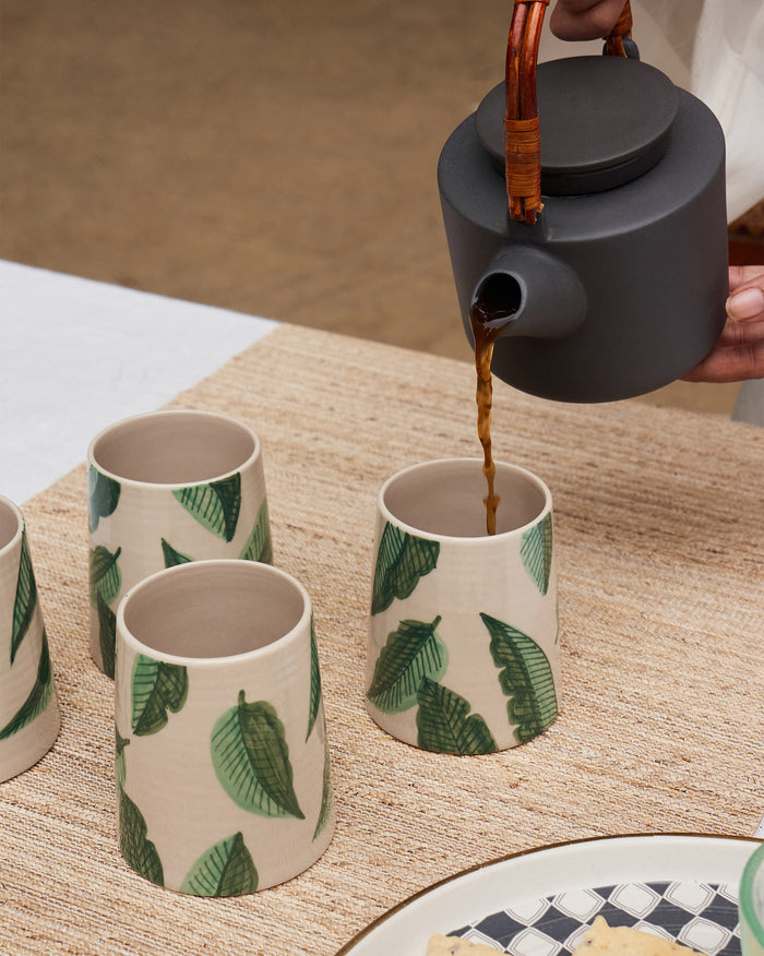 Galle kulhars with green banana leaf print as tea is poured.
