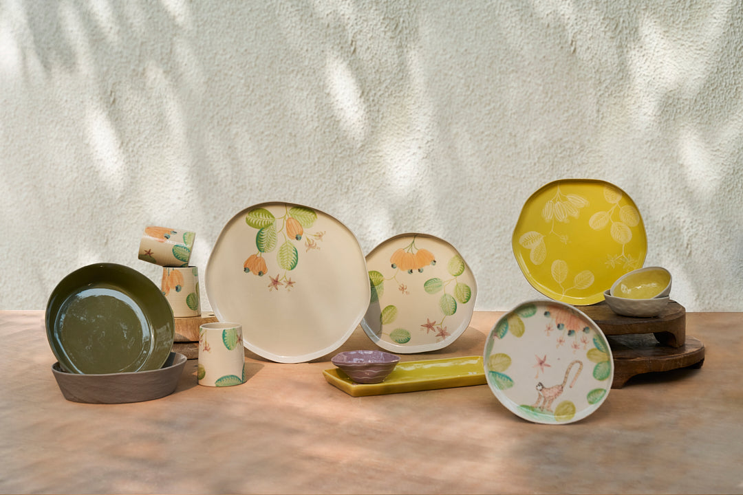Mandovi Dinner Plate with other Mandovi pieces set out on a table.