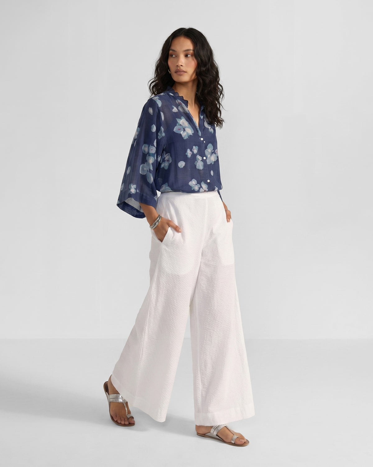 Person wearing a navy Lina shirt with slip in blue-white bougainvillea print.