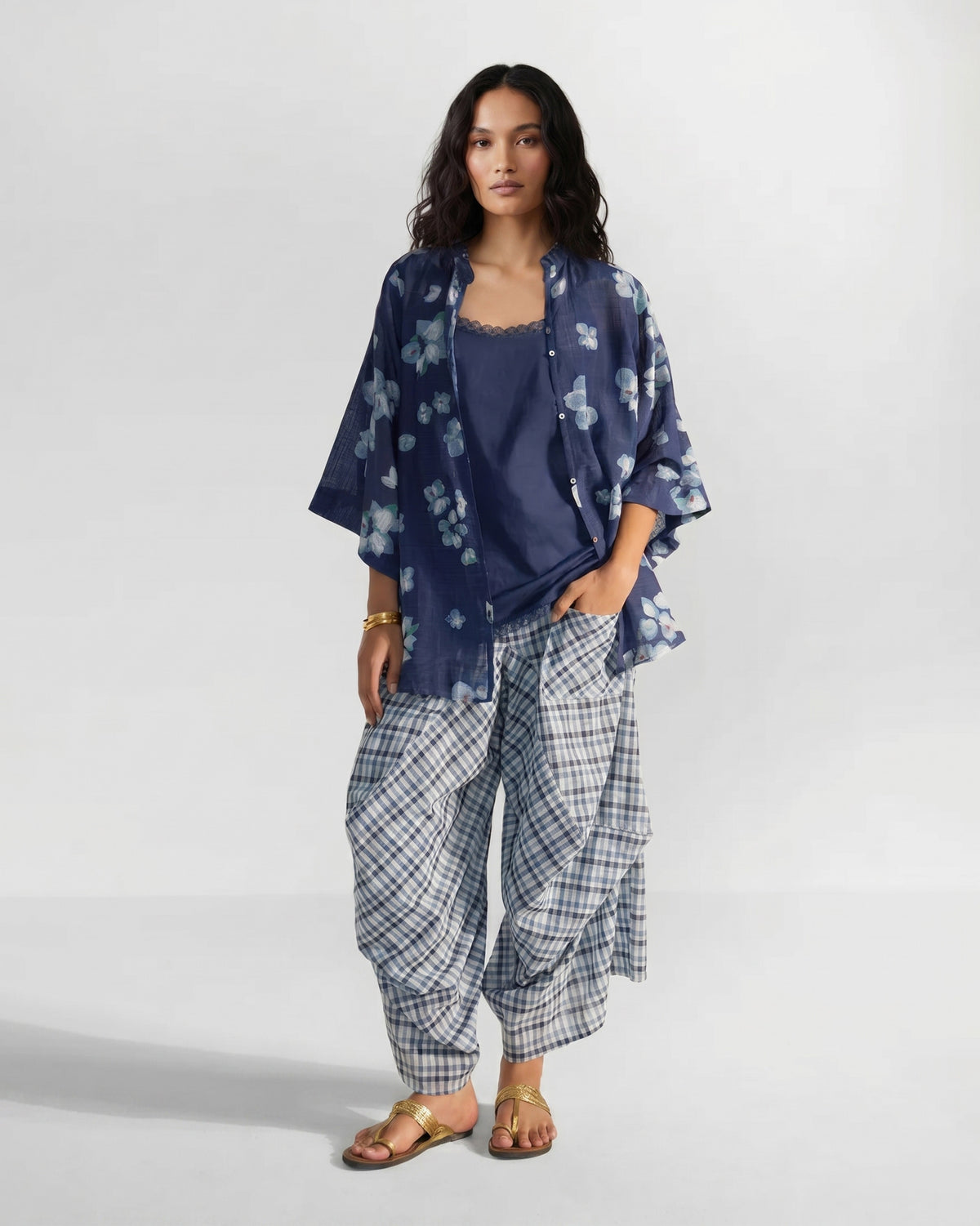 Person wearing an open navy Lina shirt with slip over a lace-trimmed navy camisole.