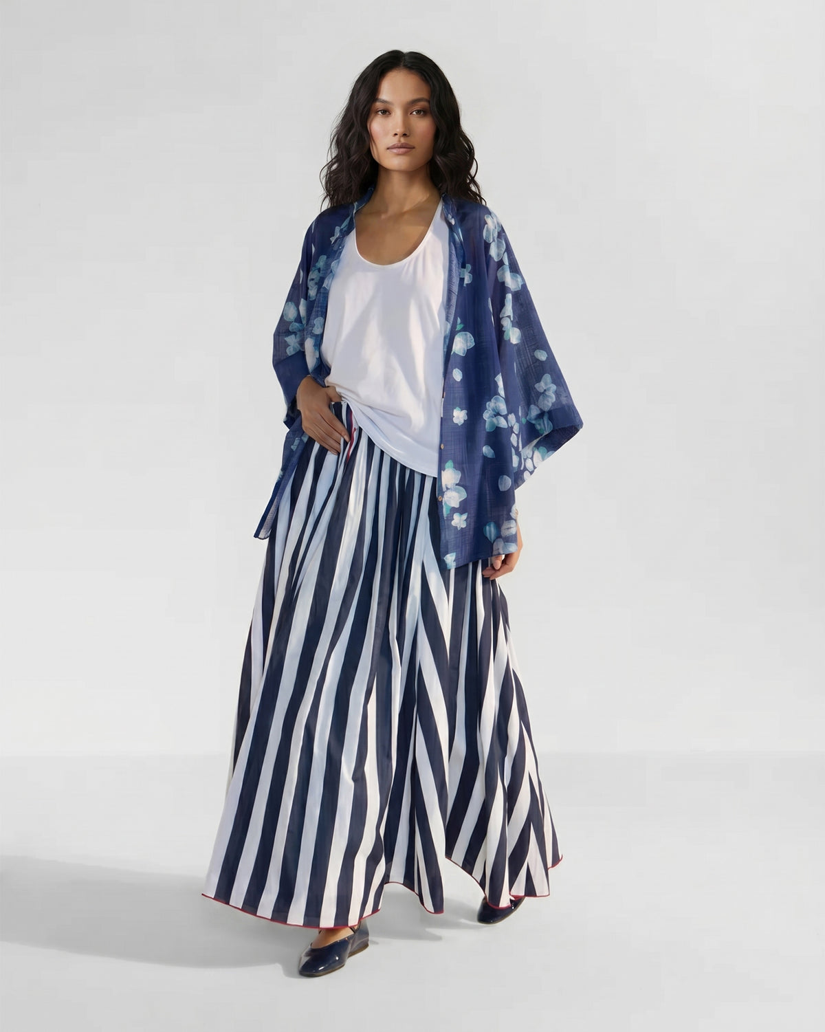 Person wearing an open navy Lina shirt with slip in blue-white bougainvillea print.
