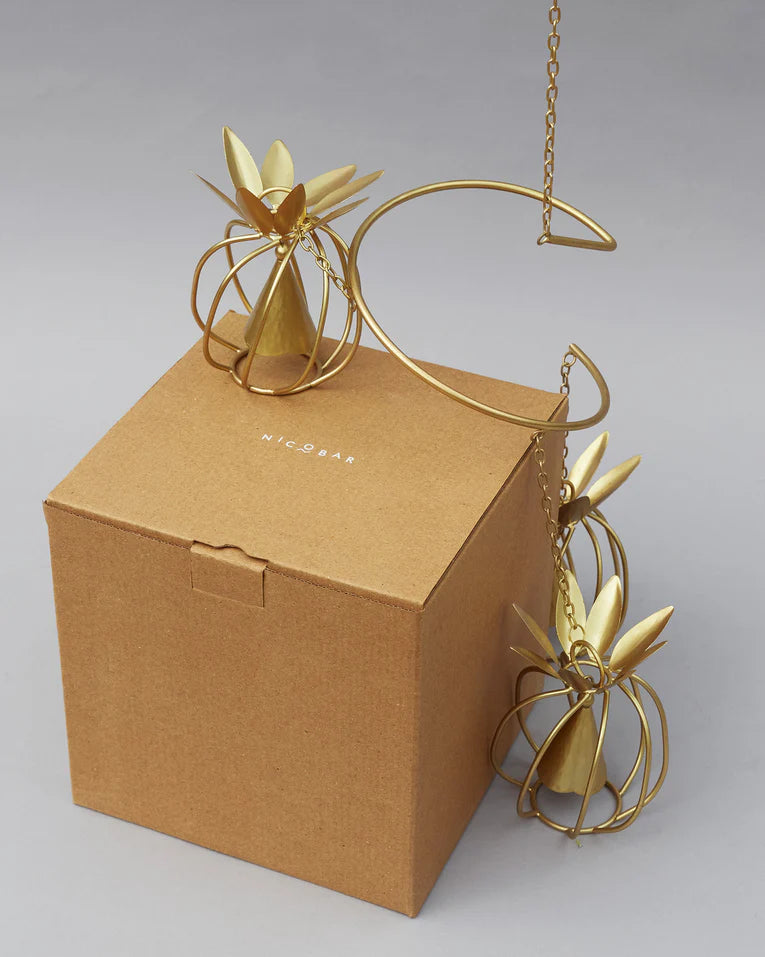 Pineapple wind chime draped over a Nicobar gift box.
