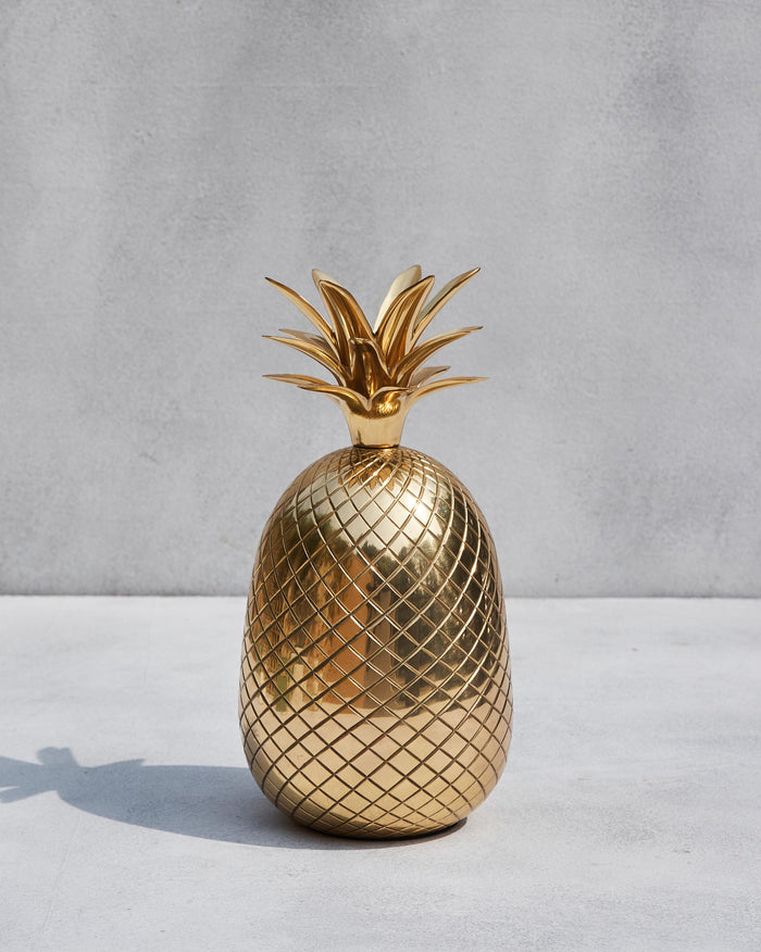 Polished brass pineapple décor with a diamond-patterned body and leafy crown.