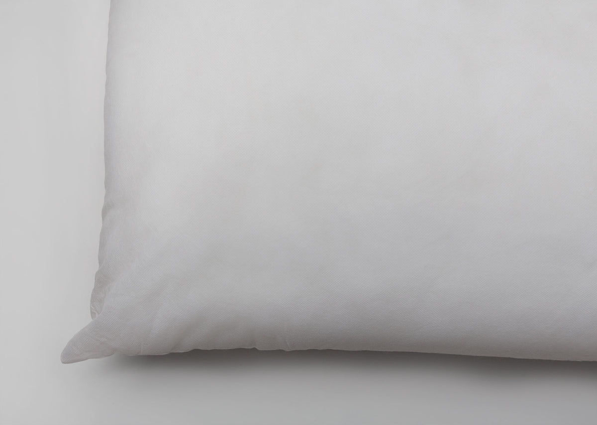 Close-up of the seamed corner of a white Pillow Filler 36 x 91 cm.