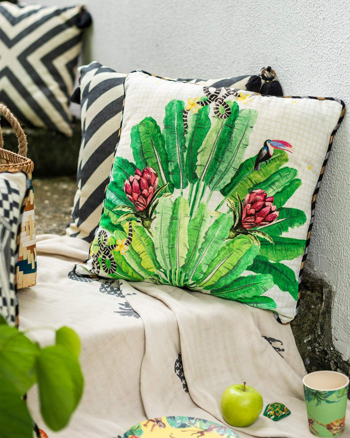 Madagascar cushion cover at an angle, showing red proteas and a toucan.