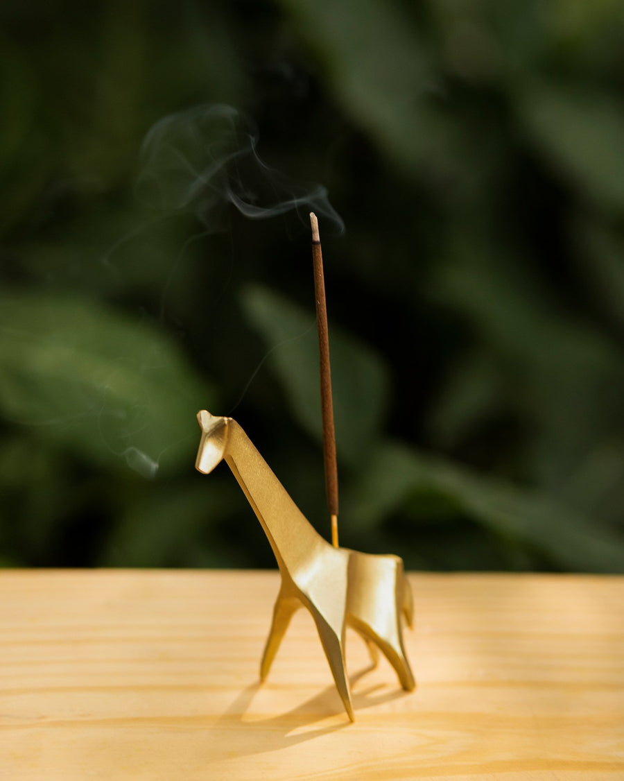 A Nerola stick burning in a gold holder.