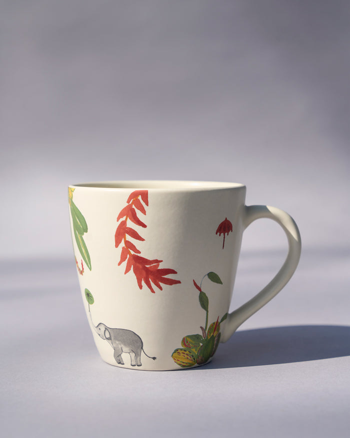 Side view of a Thazin conical mug with an elephant and red flowers.