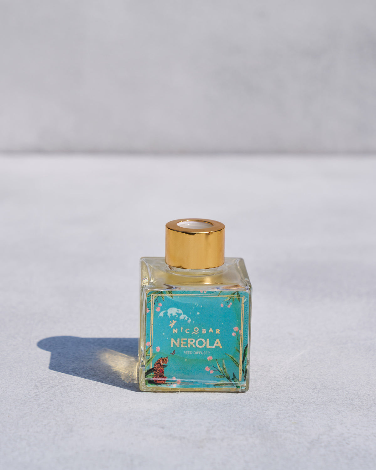 Nerola reed diffuser bottle without reeds, showing its gold cap.