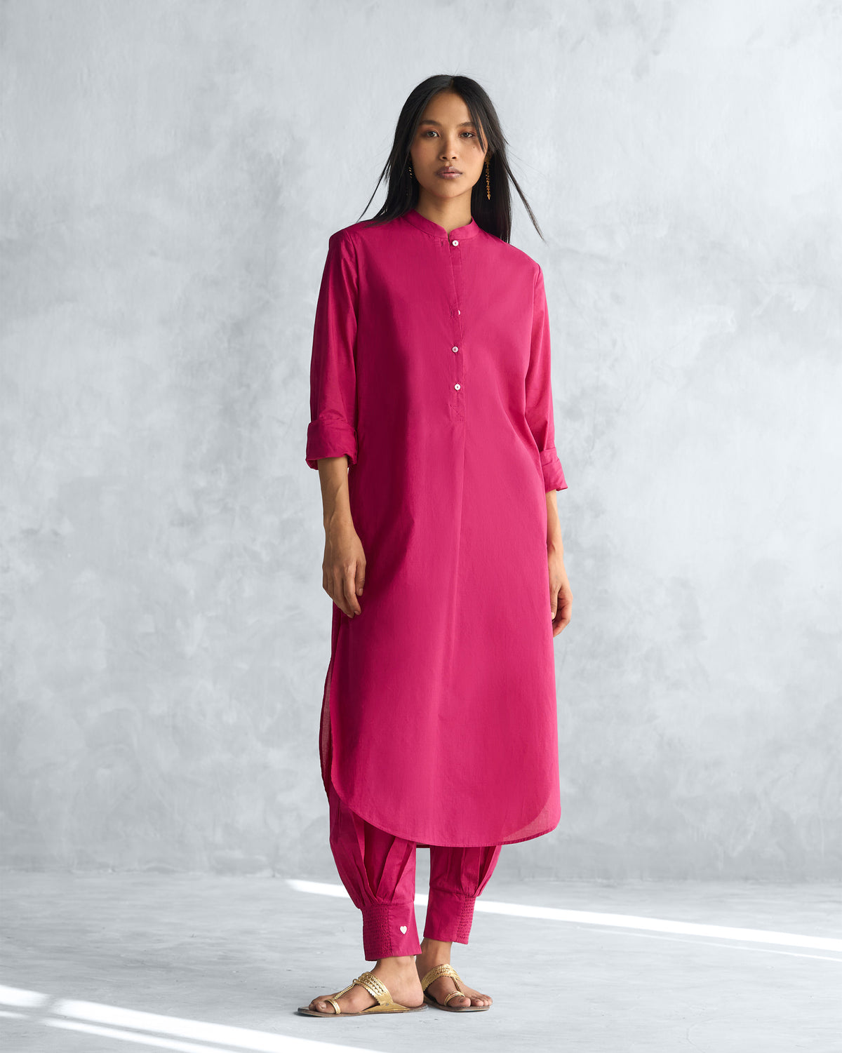 Person wearing a berry long kurta with a mandarin collar and curved hem.