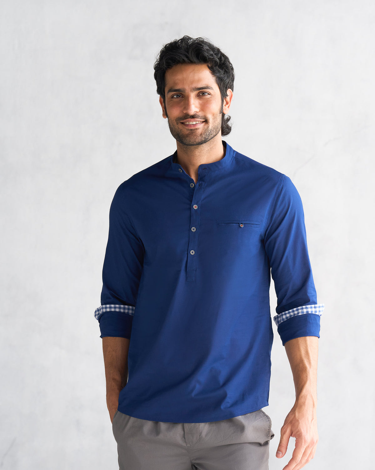 Person wearing a blue Pondicherry shirt with mandarin collar and rolled sleeves.
