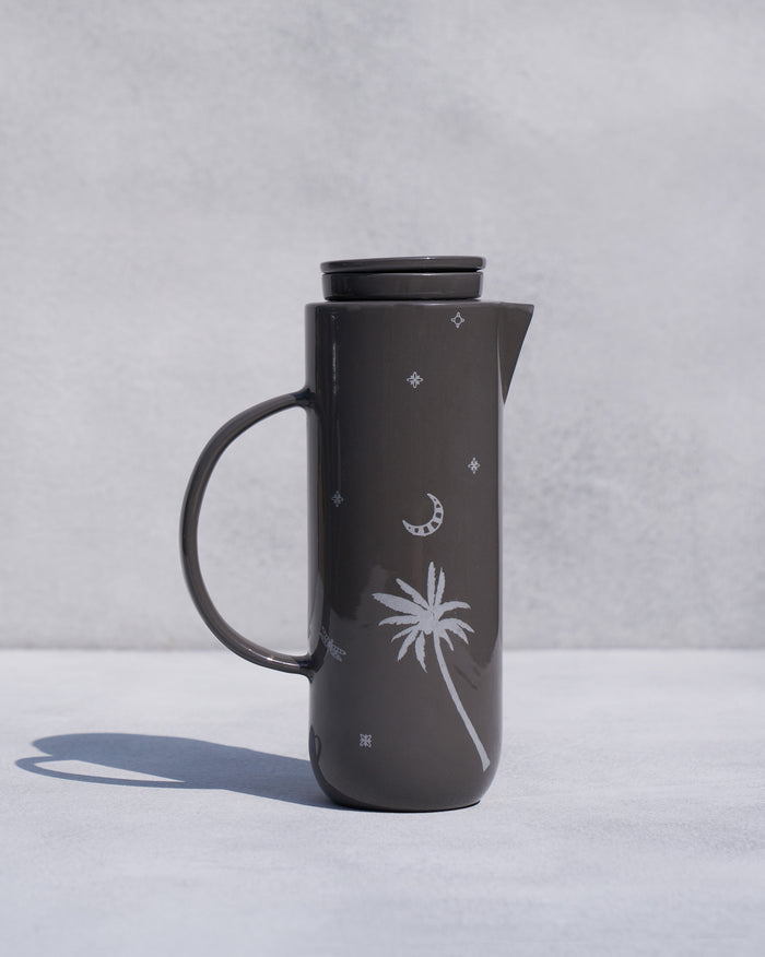 Taramandal Carafe, a dark grey carafe with a white palm, moon and star motif.