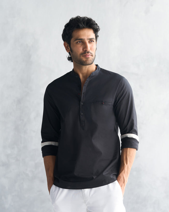Person wearing a black Pondicherry shirt with a button placket.