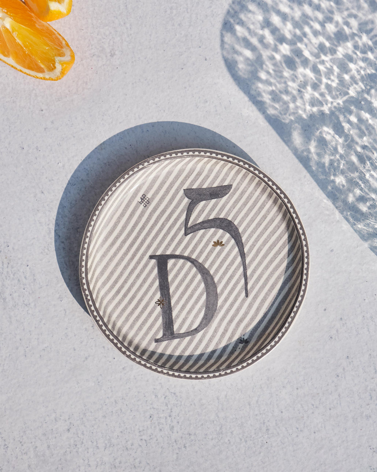 The Akshar Coaster with a charcoal D.