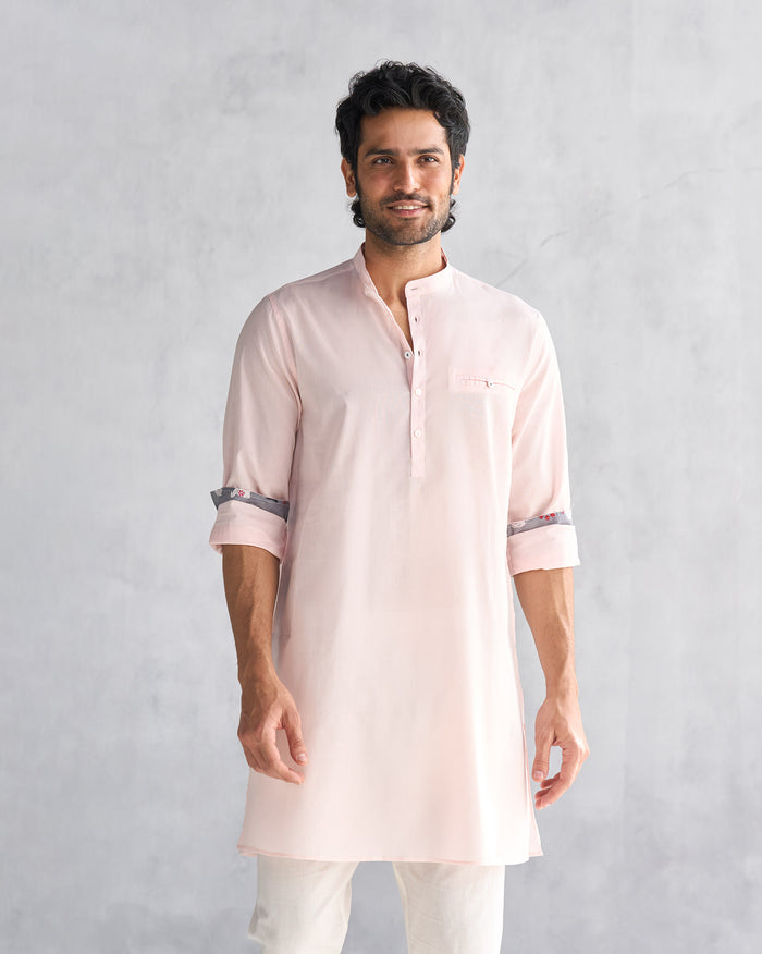 Person wearing a pink Pondicherry kurta with patterned cuff lining.