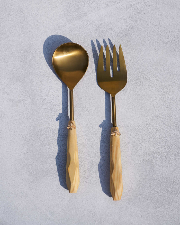Pair of Bee Salad Servers laid flat with gold bee motifs on the handles.