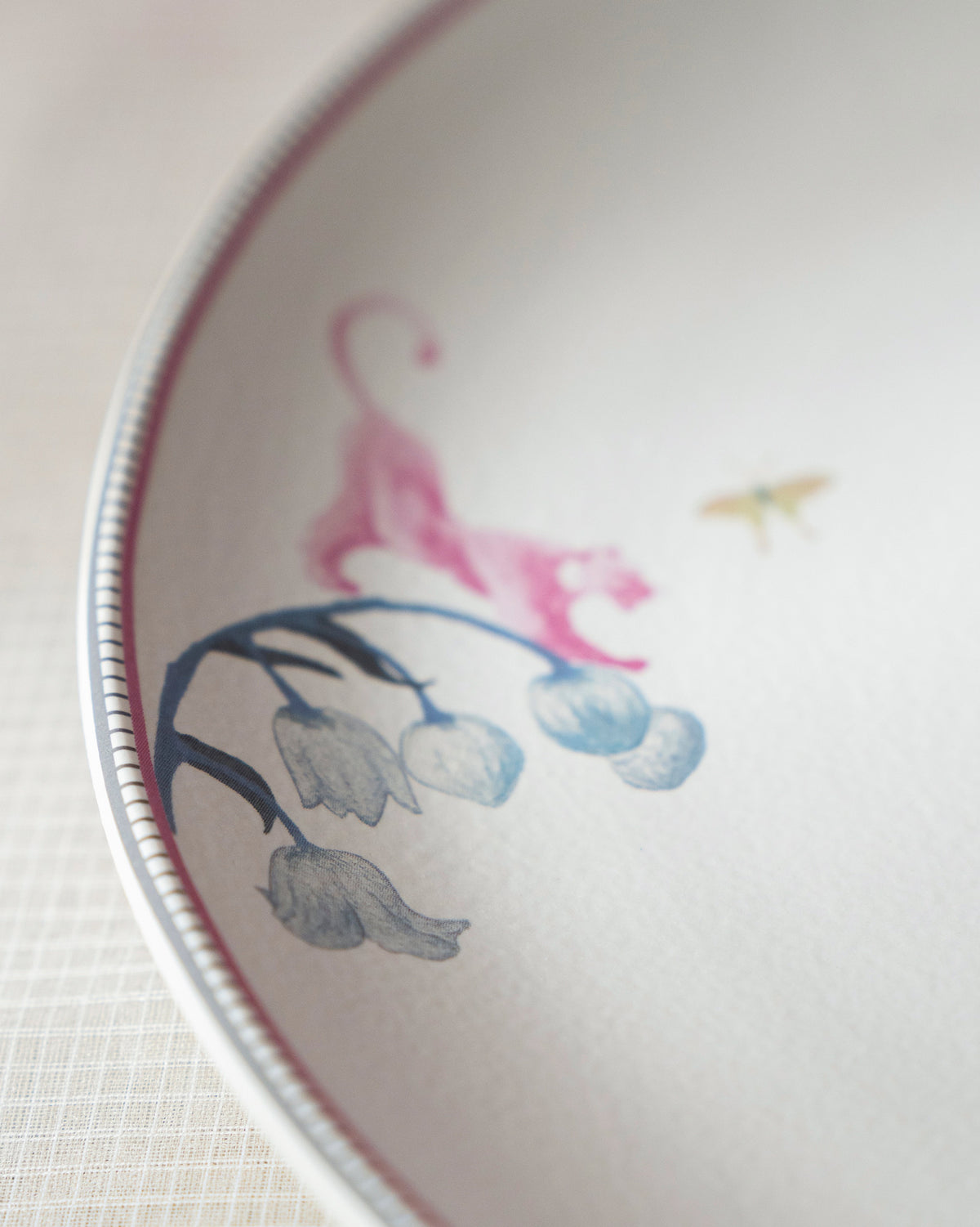 Close-up of a Myra dinner plate showing a pink tiger and blue flowers.