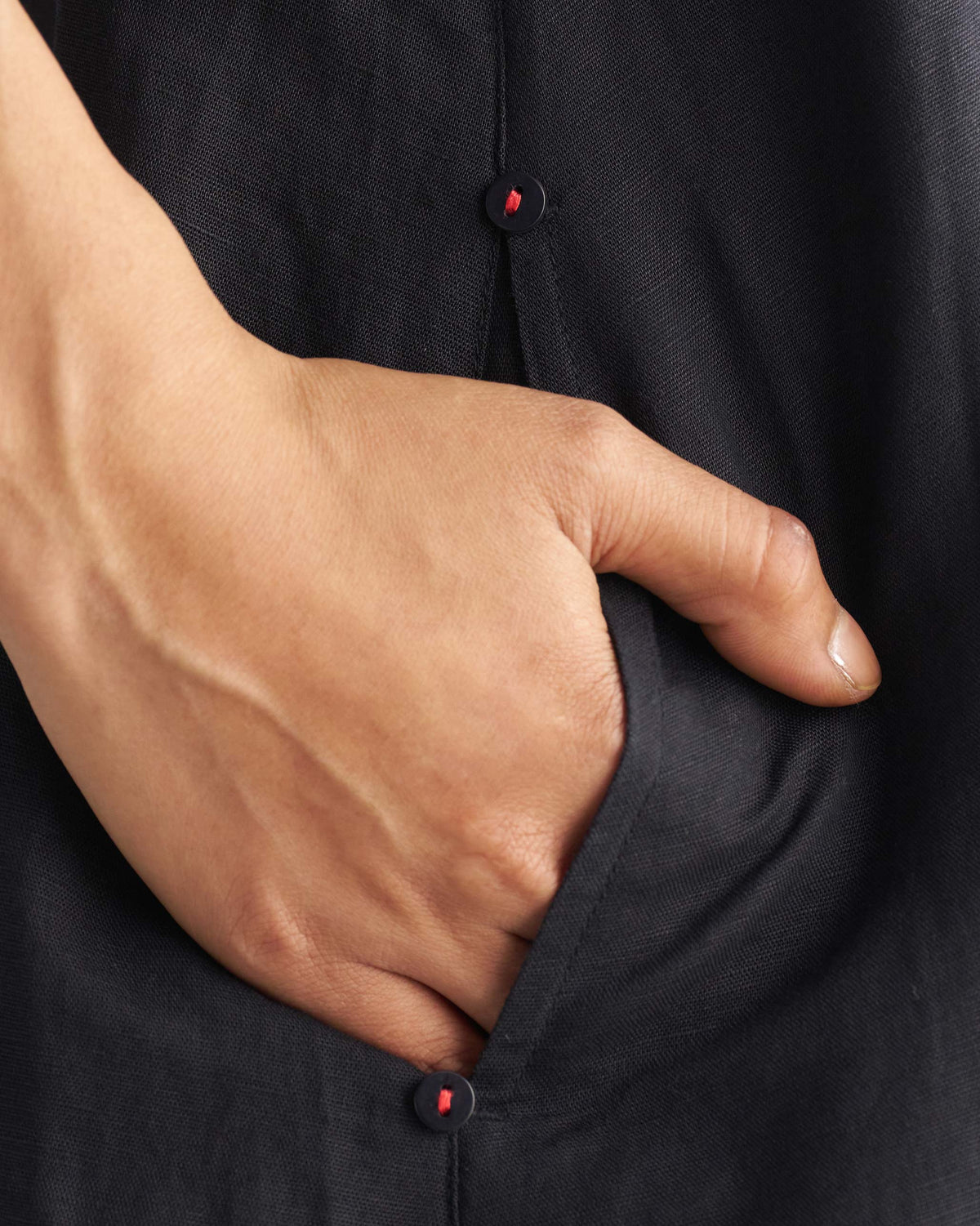 Close-up of a black Double layer dress pocket with small buttons.