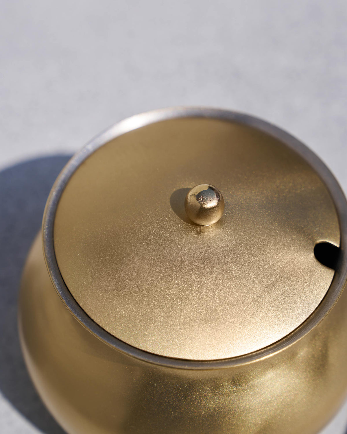 Close-up of the Madhu ghee pot lid with a knob and spoon notch.