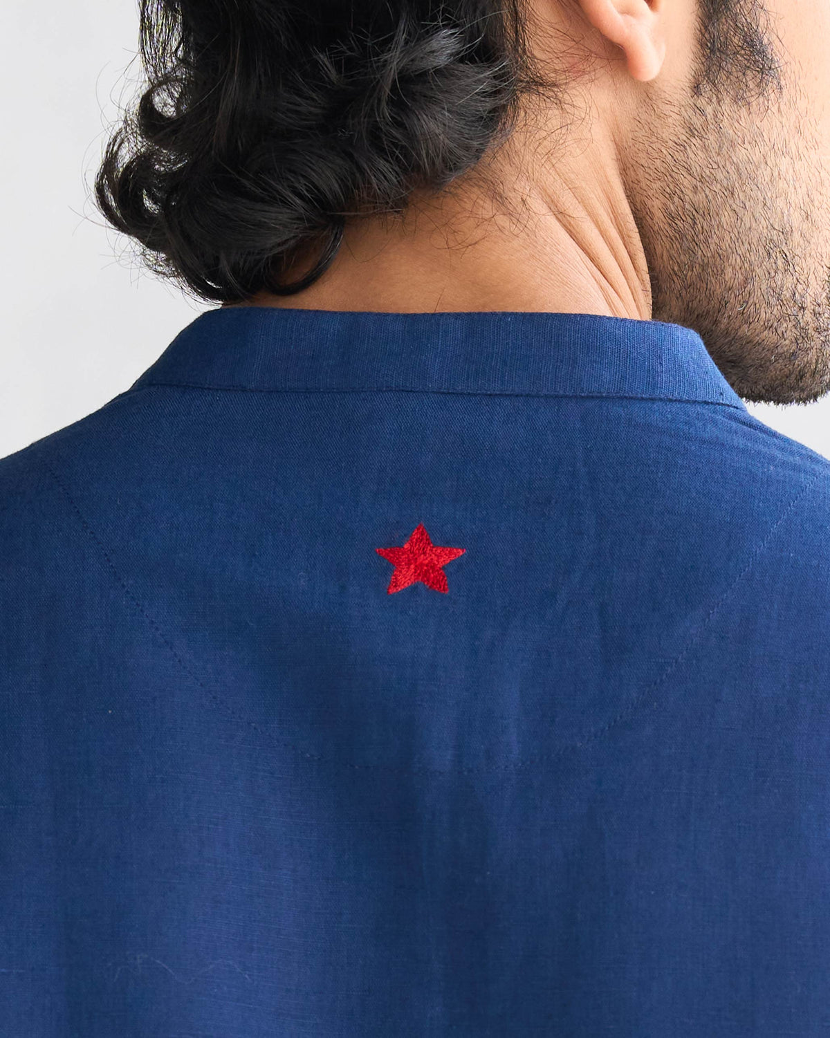 Close-up of the red star embroidery on a navy Chandni Chowk kurta.