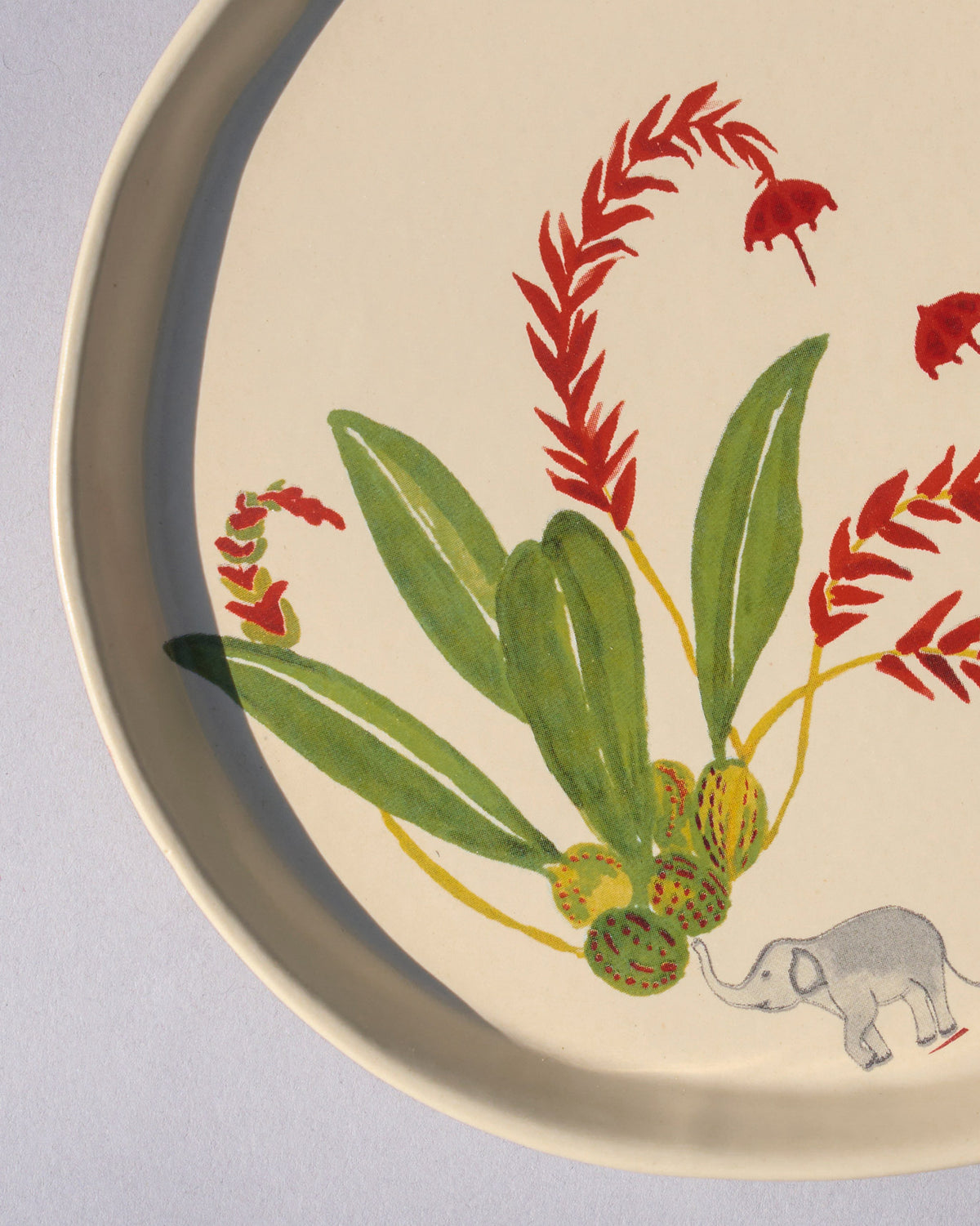 Close-up of the Thiri dessert plate showing an elephant and red flowers.